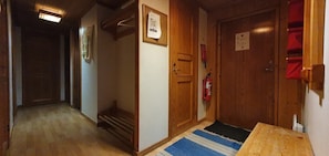 A hallway with wooden doors, a fire extinguisher, and a blue rug. - Sauna | Wi-Fi | Terrace | Wood stove | Cable TV (Lofsdalen)