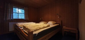 A wooden room with a bed, a window with curtains, and a small table. - Sauna | Wi-Fi | Terrace | Wood stove | Cable TV (Lofsdalen)