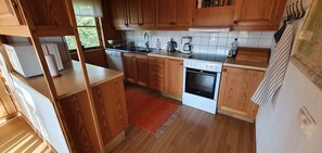 Eine Küche mit Holzausstattung, Geschirrspüler, Herd und Kaffeemaschine.