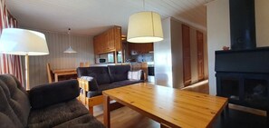 Ein gemütliches Wohnzimmer mit einer Couch, einem Holztisch und einem Kamin.