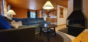 Ein gemütliches Wohnzimmer mit einer Couch, einem runden Tisch und einem Kamin.