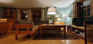 Ein gemütliches Wohnzimmer mit einer Couch, einem Couchtisch und einem Fernseher.
