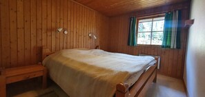 A wooden-paneled room with a bed, a bench, and a window with curtains. - Sauna | Wi-Fi | Terrace | Wood stove | Cable TV (Lofsdalen)