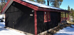 Eine kleine, eingeschossige Holzhütte mit rotem Dach und der Nummer 37 an der Seite.