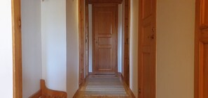 A wooden hallway with a door at the end, a rug on the floor, and wooden walls. - Sauna | Wi-Fi | Terrace | Wood stove | Cable TV (Lofsdalen)