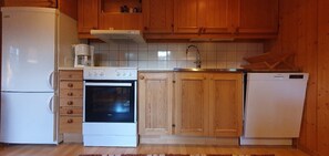 Eine Küche mit Holzausstattung, einem weißen Kühlschrank, einem Herd und einem Geschirrspüler.