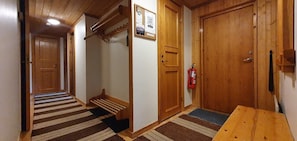 Ein Korridor mit Holztüren, einem Feuerlöscher und einer hölzernen Bank.