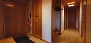 Ein Holzbodenkorridor mit Feuerlöscher, einer Tür und einer Treppe.
