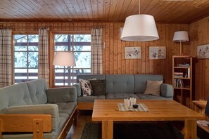 Ein gemütliches Blockhausschlafzimmer mit einer Couch, einem Holztisch und einem Bücherregal.