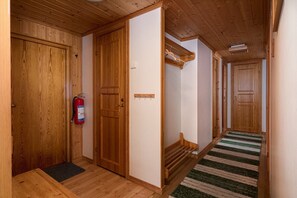 Ein Holzflur mit einem Feuerlöscher, einer Bank und einem Streifen Teppich.