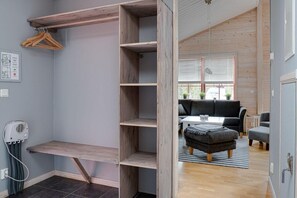 A room with a wooden wardrobe, a radiator, and a seating area with a sofa and ottoman. - Sauna | Ski-in/out | Wi-Fi | Ski shed | Wood stove (Lofsdalen)