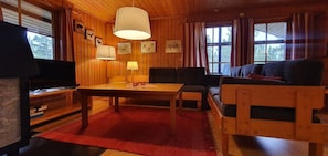 Ein Holzinnenraum mit einer Couch, einem Tisch und einem Fernseher.