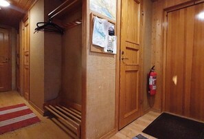 Ein Holzkoffer mit einem Feuerlöscher, einer rot-weiß gestreiften Teppich und einer schwarzen Fußmatte.