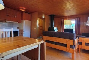 Ein Holzinterieur mit einer Küche, einem Essbereich und Sitzgelegenheiten.