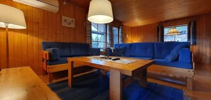 A wooden interior with a sofa set, a table, and a lamp. - Sauna | Wi-Fi | Terrace | Wood stove | Cable TV (Lofsdalen)