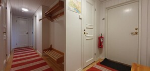 Ein Flur mit rotem Teppich, einer Holzbank, weißen Türen und einem Feuerlöscher.