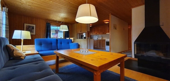 Ein gemütliches Wohnzimmer mit einer Couch, einem Holztisch und einem Kamin.