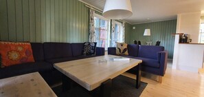 Ein Wohnzimmer mit einer Sofagarnitur, einem Holztisch und einer Lampe.