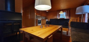 Ein Holzespeisesaal mit Kerzen, eine Couch und eine Küchenzeile mit Holzschränken und einem Herd.