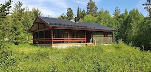 Eine Holzhütte mit Metall-Dach und Veranda.