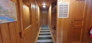 Ein Holzbodenkorridor mit einer Karte, einem Feuerlöscher und einem Poster an der Wand.