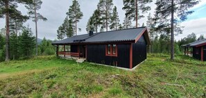 Eine Holzhütte mit Metall-Dach und einer Veranda.