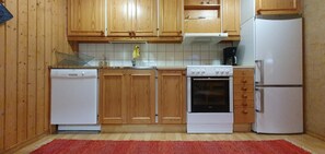 A kitchen with wooden cabinets, a white dishwasher, a stove, and a refrigerator. - Sauna | Wi-Fi | Terrace | Wood stove | Cable TV (Lofsdalen)