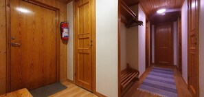 Eine Holztür mit einem Feuerlöscher, ein Flur mit einem Streifen Teppich und eine Holztreppe.