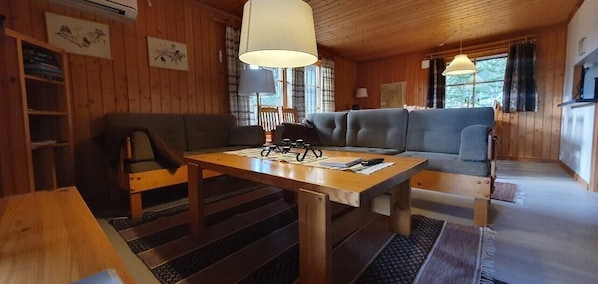 Ein Holzinterieur mit einer Couch, einem Tisch und einer Lampe.