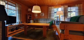 A wooden interior with a sofa, table, and lamps. - Sauna | Wi-Fi | Terrace | Wood stove | Cable TV (Lofsdalen)