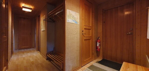 A hallway with wooden doors, a fire extinguisher, and a map on the wall. - Sauna | Wi-Fi | Terrace | Wood stove | Cable TV (Lofsdalen)