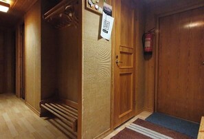 Ein Zimmer mit Holzboden, einer Tür, einem Feuerlöscher und einer Matte.