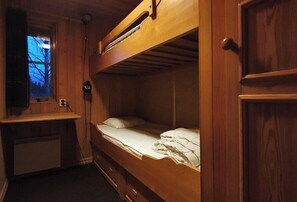 Ein Stockbett mit Schreibtisch und Fenster.