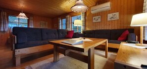 Ein Holzinterieur mit einer Couch, einem Tisch und einer Lampe.