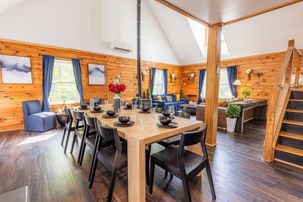 L’intérieur d’un chalet en bois comprend un coin repas, un canapé et un escalier.