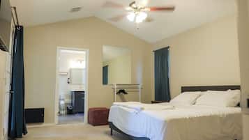 Ein Hotelzimmer mit Bett, Deckenventilator, Spiegel und einer Tür zu einem Badezimmer.