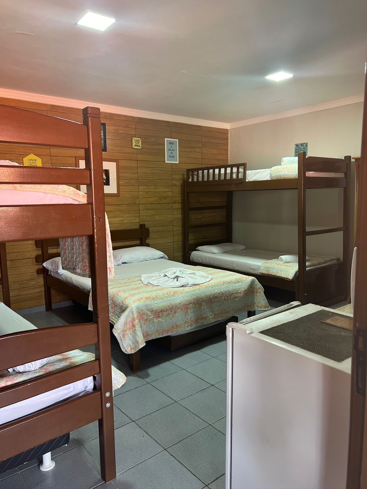 Un dormitorio con literas, un escritorio pequeño y piso de baldosas.