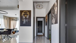 A modern interior with a dining area, a hallway with artwork, and a door leading to another room. - Fortunata by Interhome (Zadar/Bibinje)