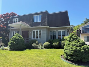 A two-story house with a front porch, a garage, and a well-maintained lawn. - 1 Silver Ln- NEW LISTING!!- Escape to the perfect beach retreat, ideally located on the tranquil shores of Silver Lake. (Rehoboth Beach)
