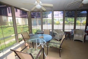 A sunroom with a glass table, chairs, and a ceiling fan. - 1 Silver Ln- NEW LISTING!!- Escape to the perfect beach retreat, ideally located on the tranquil shores of Silver Lake. (Rehoboth Beach)