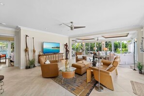 A spacious living area with a large TV, comfortable seating, and a view of the outdoors. - Las Olas Waterfront Home | Heated Pool, Yacht Dock (Fort Lauderdale)