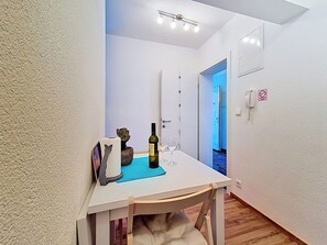 A narrow hallway with a table set for two, a bottle of wine, and a glass. - Apartment Palma by Interhome (Stanići)