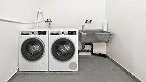 Een wasserette met twee voorladers en een metalen wasbak.