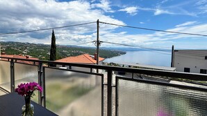 Ein Balkon mit Blick auf einen See und ferne Hügel.