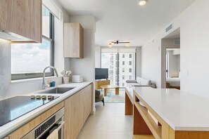 Eine moderne Küche mit großem Fenster, eingebauten Geräten und Blick auf die Stadt.