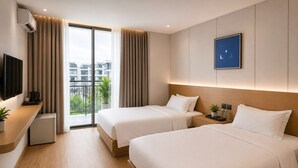 Habitación de hotel con dos camas, televisión, cafetera, una planta y vista a la ciudad.