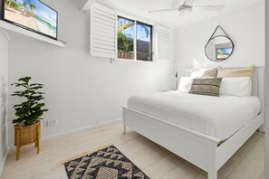 A white bedroom with a bed, a ceiling fan, a window with shutters, a mirror, and a plant. - The Perrins Lane Compound - Reset, Relax, Enjoy! (Arakoon)