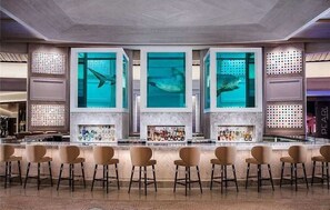 Eine Bar mit verschiedenen Sitzgelegenheiten und einem großen Aquarium.