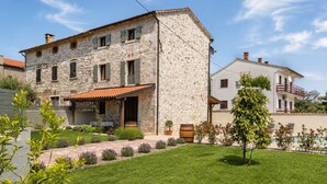 A stone building with a tiled roof, a covered patio, and a well-maintained lawn. - Dariocchi by Interhome (Poreč/Kaštelir)