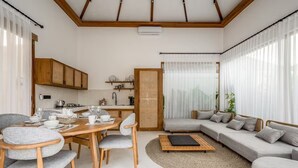 Ein modernes Wohnzimmer mit Essbereich, einer Sofagarnitur und einer Küche im Hintergrund.
